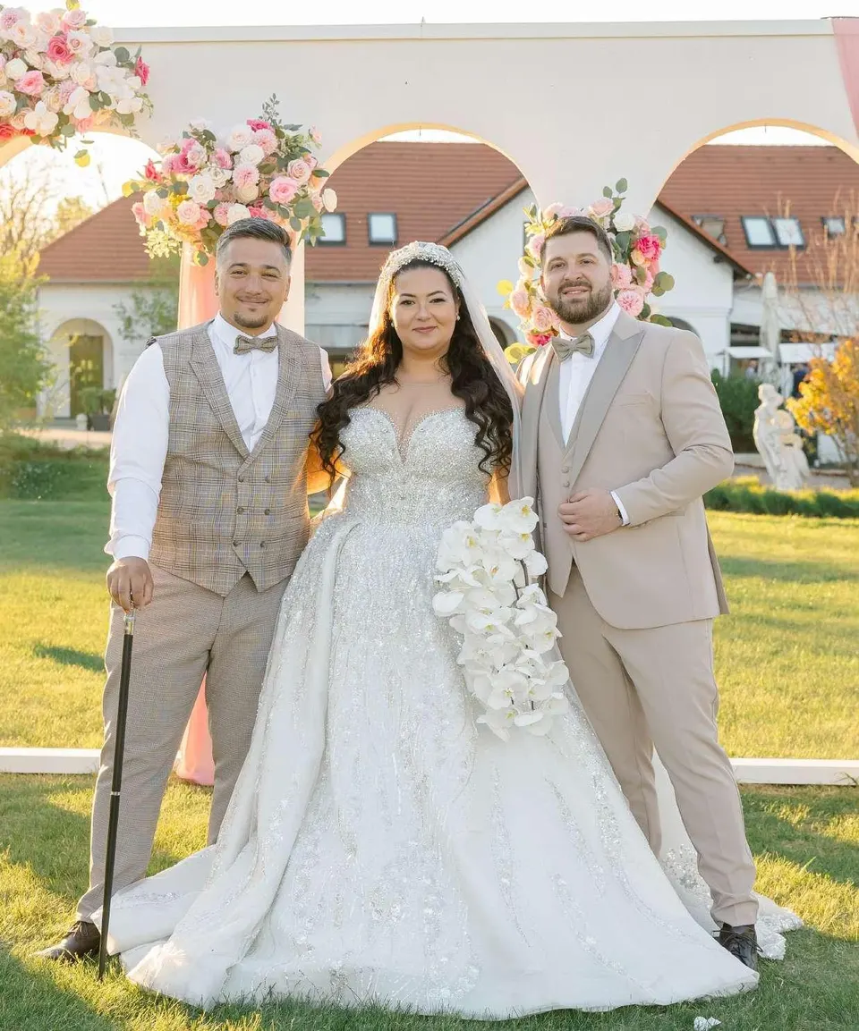 Dóri és Ákos Patrikkal virágos kapu előtt