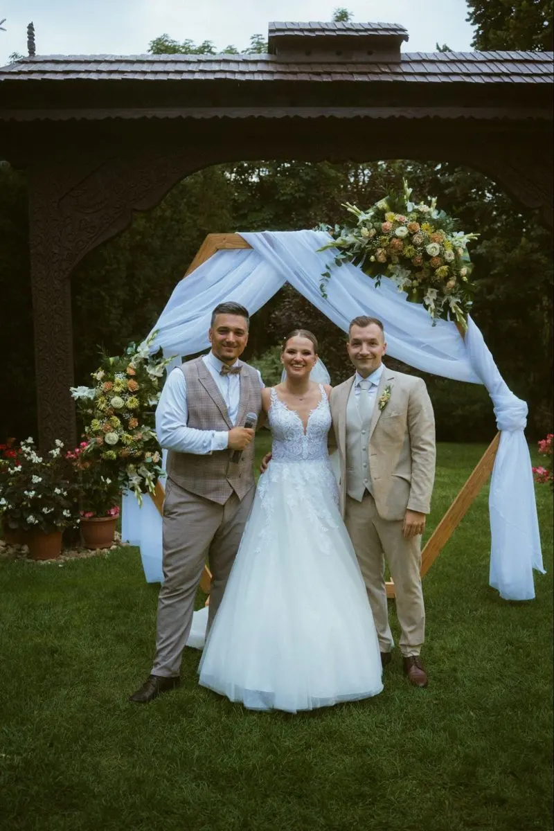 Dorina és Bence Patrikkal egy virágos szertartási kapu előtt